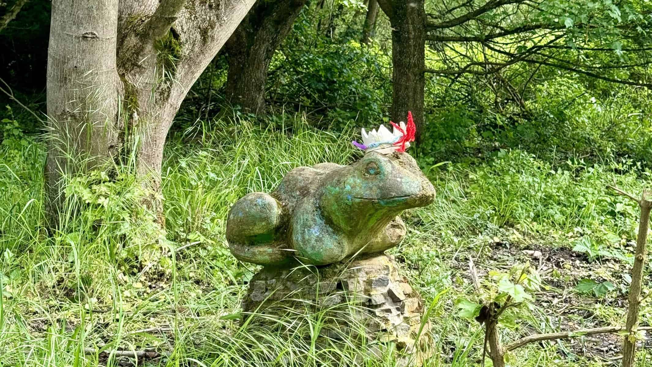 The “kiss the frog” statue placed near a hiking trail. Currently it wears a self-made crown by someone.